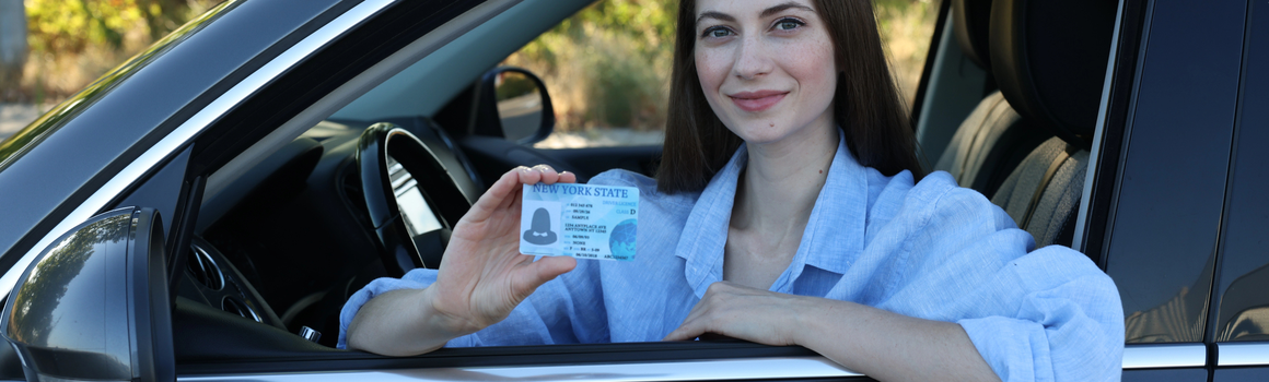 žena v autě s řidičským průkazem